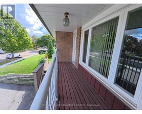 A balcony with a white railing and a brick wall.