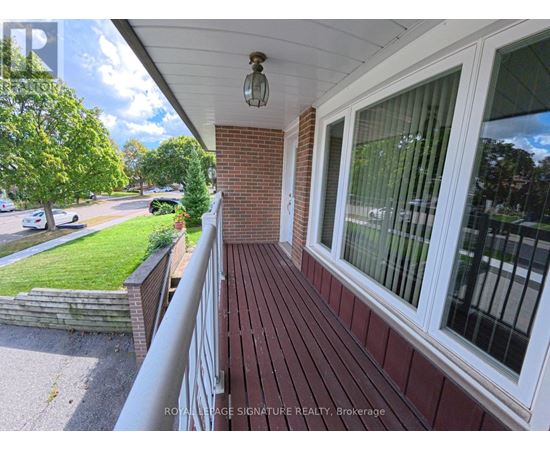 A balcony with a white railing and a brick wall.