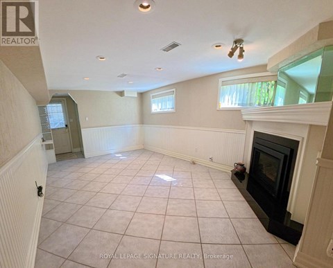 A living room with a fireplace and a ceiling fan.