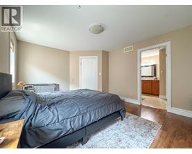 A bedroom with a bed, dresser, and mirror.