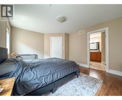 A bedroom with a bed, dresser, and mirror.