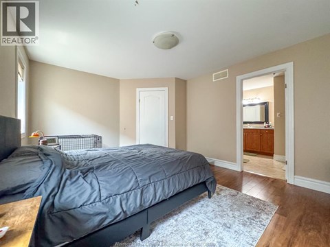 A bedroom with a bed, dresser, and mirror.