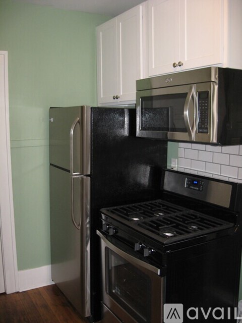 A black fridge and microwave in a kitchen.