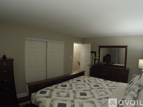 A bedroom with a bed, dresser, and mirror.