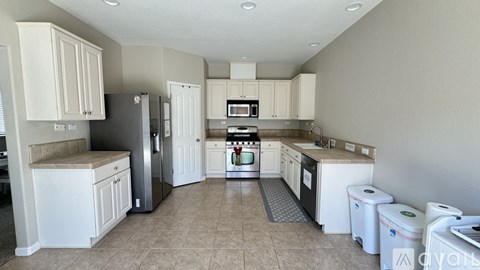 A kitchen with white cabinets and appliances.