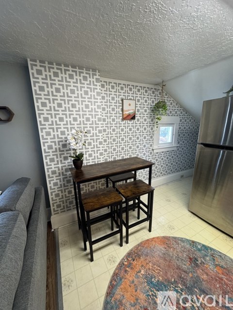 A small dining table with two chairs sits in a kitchen.