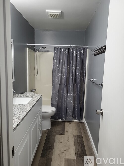 A bathroom with a toilet, sink, and shower.