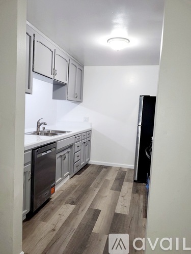 A kitchen with wooden floors and white walls.