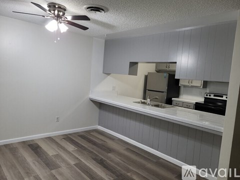 A kitchen area with a fan and a countertop.