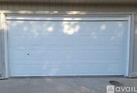 A white garage door is closed and has a lock on it.