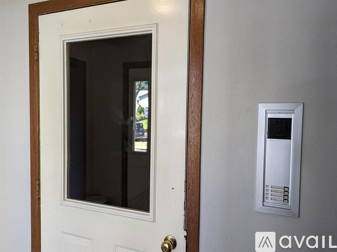 A white door with a window and a mail slot.