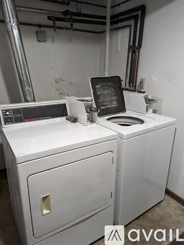 A white washing machine with a digital display and a black top sitting in a room.