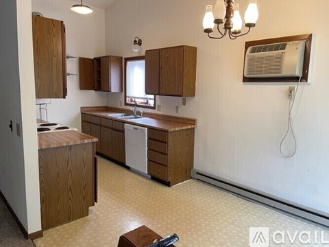 A kitchen with wooden cabinets and a white dishwasher.