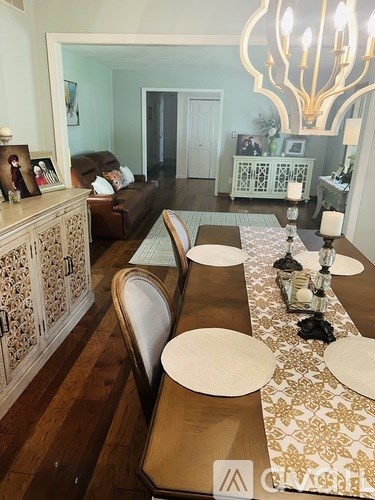 A dining room with a long table and chairs.