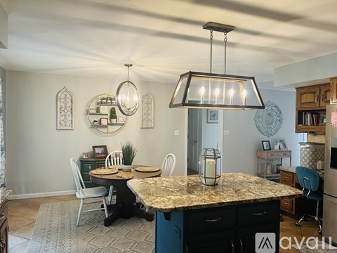 A kitchen with a table and chairs in the middle of the room.