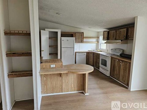 A kitchen with a white refrigerator, wooden island, and wooden cabinets.