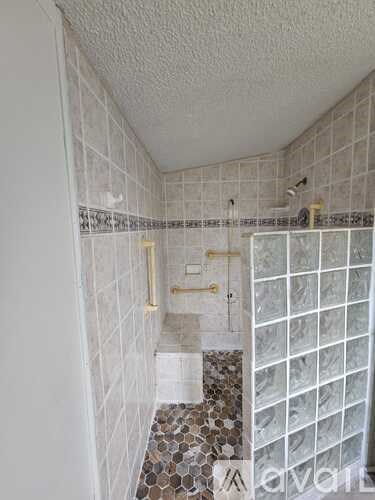 A bathroom with a shower and tiled walls.