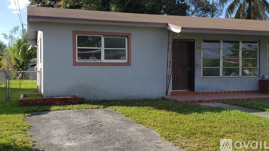 A small white house with a brown door and windows.