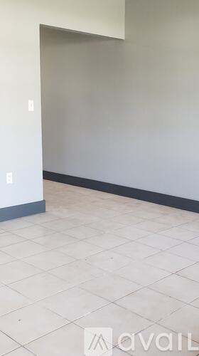 A room with a white tile floor and a white wall.