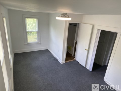 A room with a grey carpet and white walls.