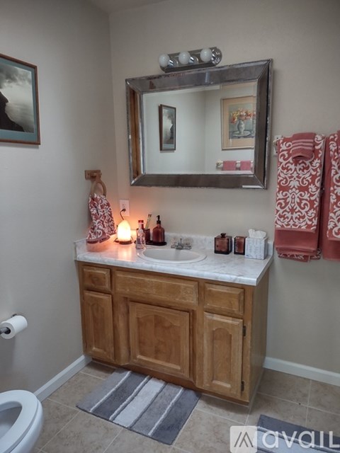 A bathroom with a wooden vanity and a mirror above it.