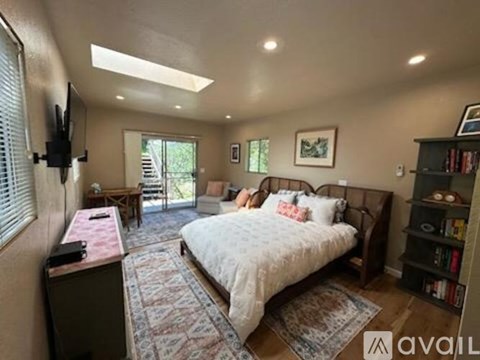 A bedroom with a bed, a desk, and a bookshelf.