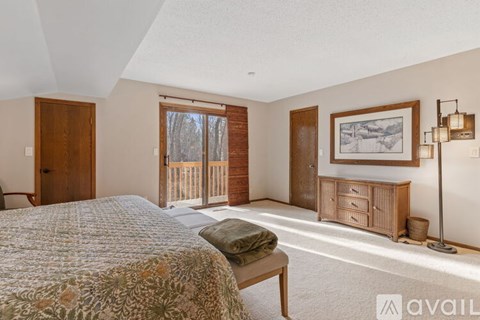 A bedroom with a large bed and a wooden cabinet.