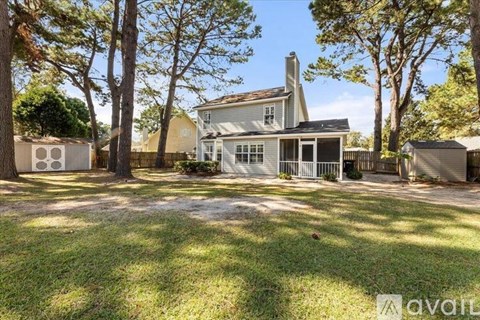 A house with a fence and trees in front of it.