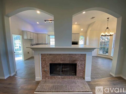 A large open living room with a fireplace and arched doorways.