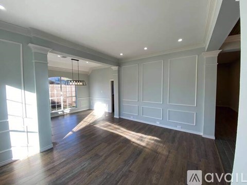 A spacious room with wooden floors and white walls.
