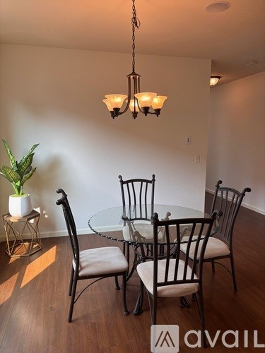A dining room with a glass table and chairs.