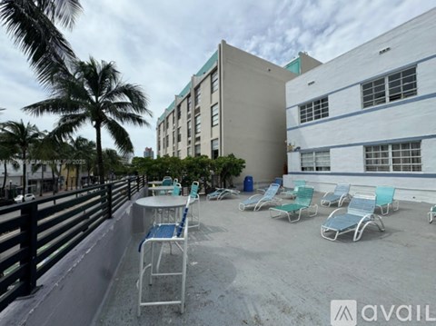 A patio with chairs and a table is in front of a building.