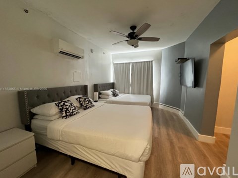 A bedroom with a large bed and a ceiling fan.