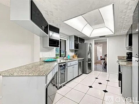 A kitchen with white tiled floors and a granite counter top.
