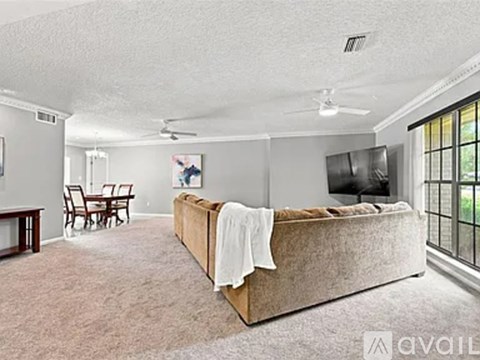 A bedroom with a bed, a dining table, and chairs.