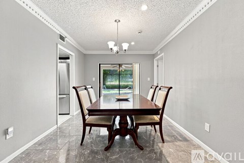 A dining room with a table and chairs.