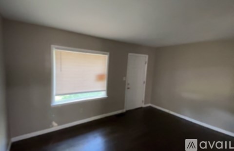 A room with a window and a door is available for rent.