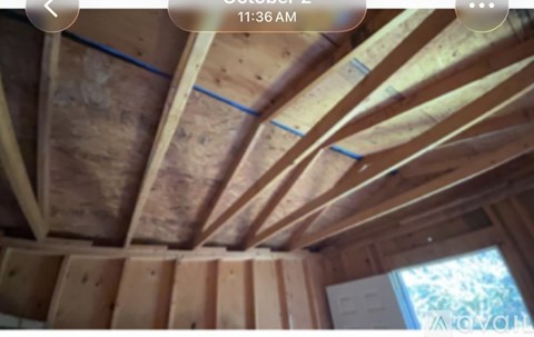 A wooden ceiling with exposed beams and a window.