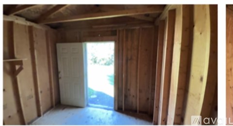 A room under construction with wooden walls and a door.