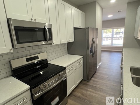 A kitchen with white cabinets and a black stove top oven.