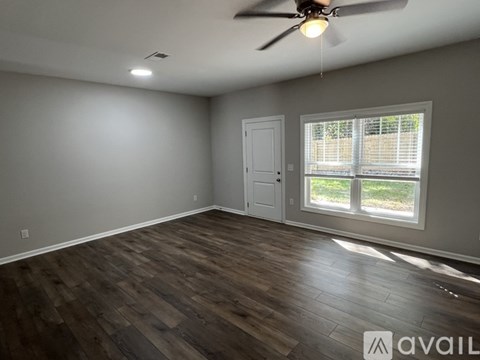 A room with a ceiling fan and a window with blinds.