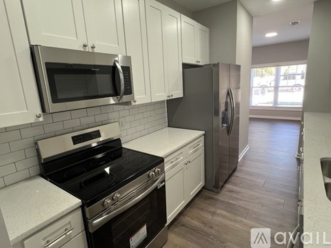A kitchen with white cabinets and a black stove top oven.