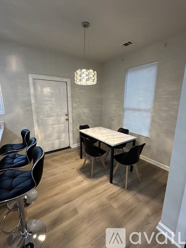 A conference room with a white table and black chairs.