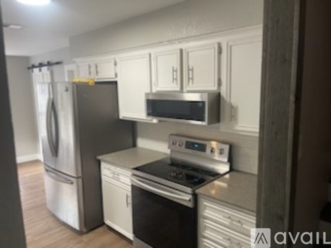 A kitchen with white cabinets and stainless steel appliances.