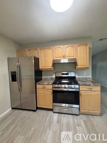 A kitchen with wooden cabinets and stainless steel appliances.