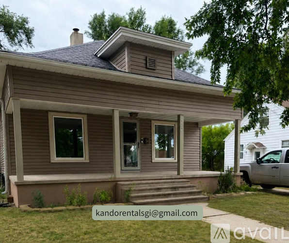 A house with a grey roof and a white car parked in front.