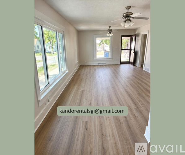 A room with wooden flooring and a ceiling fan.
