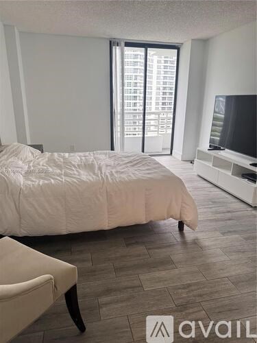 A bedroom with a large bed and a television.