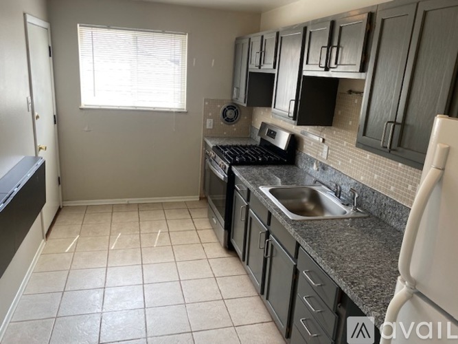 A kitchen with black appliances and a white sink.