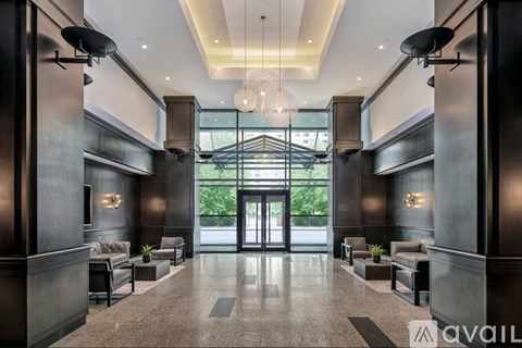 A spacious lobby with a marble floor and dark wood paneling.